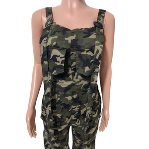 Détail de la salopette camouflage avec boucles réglables et poches cargo à rabat