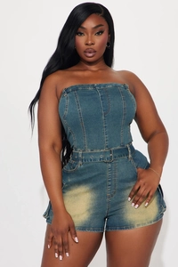 Dettaglio di una tuta aderente in denim blu con cintura e finitura slavata alla moda