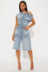 Détail d'un combishort en jean bleu clair avec design épaules nues et bords effilochés
