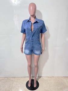 Detail of light blue denim romper featuring lapel collar, button closure and chest pocket