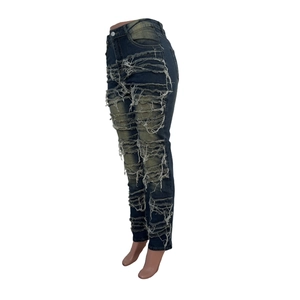 Détails d'un jean taille haute avec déchirures horizontales et délavage vintage usé