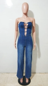Dettaglio della tuta in denim blu con scollatura a fascia e design con tagli traforati