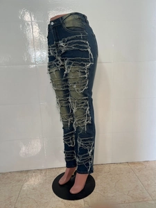 Détails du jean skinny bleu foncé avec de larges déchirures et des bords effilochés