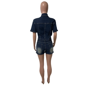 Détail des poches arrière sur une combinaison en jean bleu foncé avec effet délavé