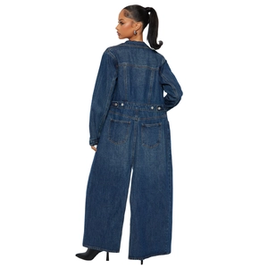 Detail view of large back pockets and metal button on dark blue denim jumpsuit