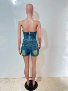 Dettaglio della tutina in denim con zip in metallo sul retro e tasche con lavaggio