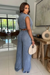 Detail of light wash blue denim two-piece set featuring backless top and wide-leg pants