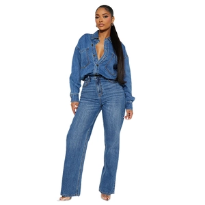 Detail of dark blue denim jumpsuit featuring a button-up front and industrial pockets