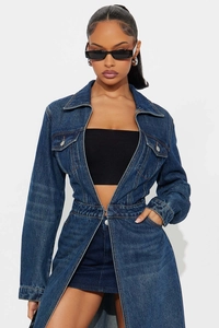 Close-up of long denim coat featuring breast pockets and metallic button details