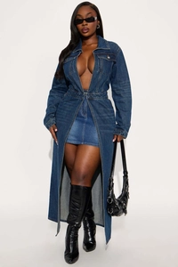 Detail view of a long denim trench coat with deep blue fabric and high-slit hem design