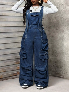 Detail of dark blue denim cargo jumpsuit featuring utility pockets and wide leg design