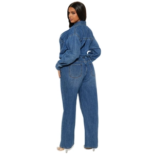 Detail view of the back seams and slim fit tailoring of a dark blue denim jumpsuit