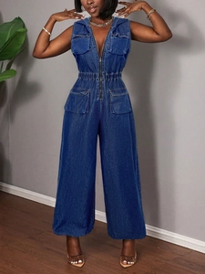 Close-up of a dark blue sleeveless denim jumpsuit with front zipper and pocket details