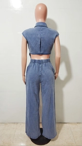 Rear view of blue denim jumpsuit featuring an elastic high waist and wide leg trousers