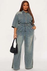 Detail of blue wash denim jumpsuit showing elastic drawstring waist and side slit leg