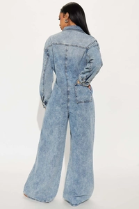 Detail view of the back seams and pocket on light blue denim flare leg jumpsuit