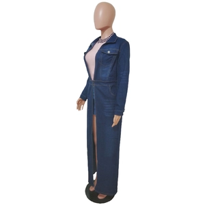 Detail view of a long denim trench coat with side slits and buttoned chest pockets