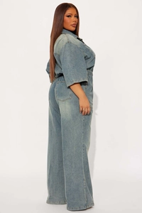 Detail view of the elastic high waist and wide leg cut on these blue denim jumpsuits