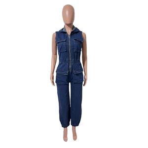 Detail of dark blue denim jumpsuit featuring utility pockets and metallic zipper closure