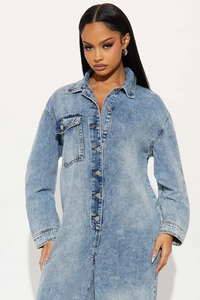 Detail of light blue washed denim jumpsuit with metal buttons and chest flap pockets