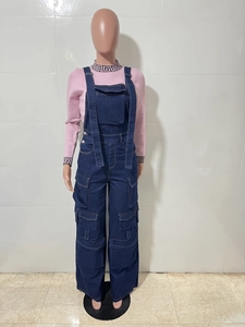 Detail of dark blue denim cargo overalls with functional pockets and knit sweater
