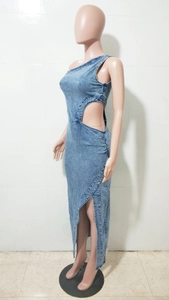 Détail d'une robe en jean bleue avec épaule asymétrique et découpe à la taille ronde