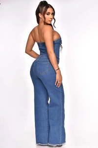 Detail showing high-waist denim jumpsuit back elasticated waist and raw hem edges