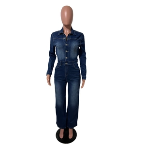 Détail de la combinaison en jean bleu foncé avec boutons en métal et taille ajustée