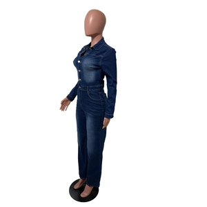 Détail des boutons métalliques et du délavage vintage sur la combinaison denim ajustée