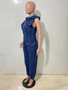 Detail view of a dark blue sleeveless denim jumpsuit with hood, zipper and utility pockets