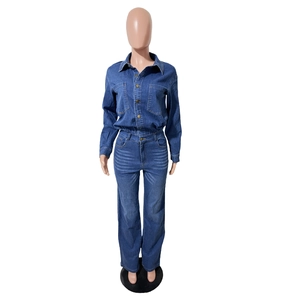 Detail of slim-fit dark blue denim jumpsuit with metal buttons and chest pockets