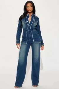 Détail de la combinaison en jean slim avec coutures à bords francs et jambes évasées