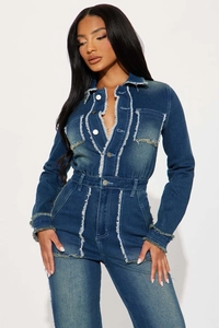 Détails de la combinaison en jean bleu foncé avec bords effilochés et boutons métalliques