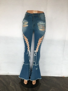 Detail der blauen Schlagjeans mit Rissen und weißer Kreuzschnürung auf der Vorderseite