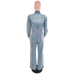 Detail view of the back of a light blue denim jumpsuit with pockets and flared leg design