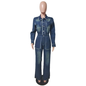 Détail des poches poitrine avec bords effilochés et boutons en métal sur une combi en jean