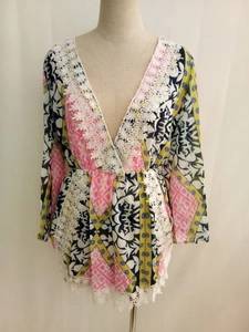 Detailed view of the deep V-neck and delicate lace trim on the floral printed romper