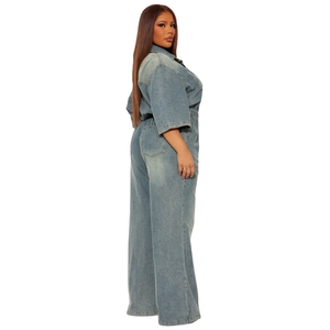 Detail of blue denim jumpsuit with elastic waist and large back pockets on white background