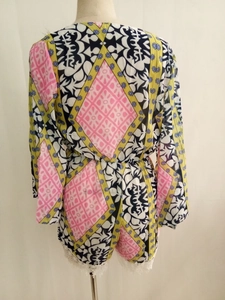 Detailed back view of a long sleeve romper with geometric floral print and lace trim