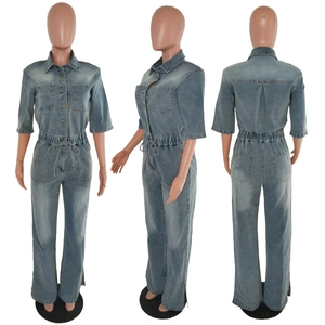 Detail of light blue washed denim jumpsuit with elastic waist and side split flare hem
