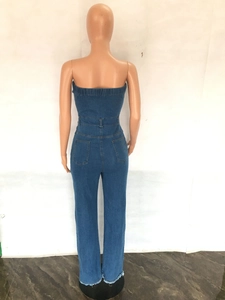 Back view of slim fit dark blue denim strapless jumpsuit with pockets and raw hem