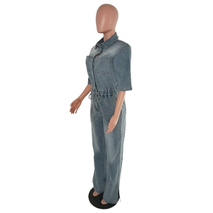 Detail view of denim jumpsuit featuring turn-down collar, chest pockets and drawstring waist