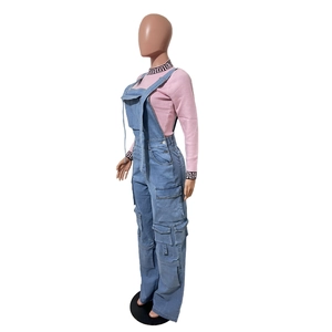 Detail view of light blue denim cargo overalls with pink long-sleeve top and fret patterns