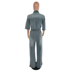 Rear view of light blue denim jumpsuit featuring elastic waist and wide leg flares