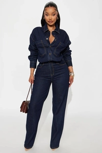 Detail of dark indigo denim jumpsuit with metal buttons and classic yellow contrast stitching