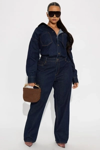 Detailed close-up showing yellow stitching on deep blue denim jumpsuit with loose-fit design