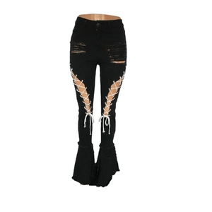 Detail von schwarzen Schlagjeans mit Distressed-Löchern und weißer Schnürung am Oberschenkel