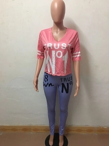 Close-up of pink V-neck T-shirt with TRUST NO 1 text and purple leggings set