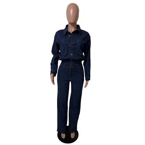 Detailed view of dark blue denim jumpsuit with chest pockets and metal buttons