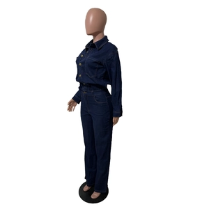 Detailed view of dark blue denim jumpsuit featuring metal buttons and slim fit high waist